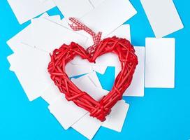 rotes Herz aus Holzweide und leere Visitenkarten aus weißem Papier foto