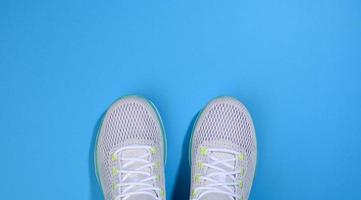 weiße damenturnschuhe mit schnürsenkeln auf blauem hintergrund foto