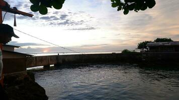 nachmittags meerblick und meermauer, strand und koralle, sonnenuntergangshintergrund am santolo beach indonesien foto