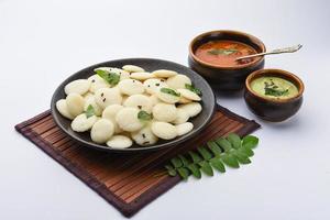 Mini-Idli ist die kleinere Version von weichem und schwammigem, rundem, gedämpftem Reis-Idli, auch bekannt als Knopf- und Cocktail-Idli foto