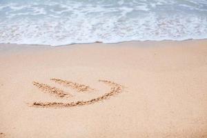 Fröhliches Lächeln auf dem Sand am tropischen Strand foto