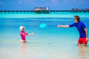 glückliches kleines Mädchen mit jungem Vater viel Spaß am tropischen Strand foto