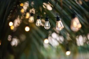 leuchtende Glühlampen hängen in Form einer Girlande. weihnachtliche warme goldgirlandenlichter. Festival-Event-Party. Girlanden, heller Weihnachtsdekorationshintergrund. party- und feierkonzept. foto