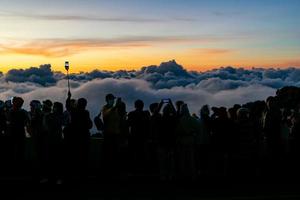 Silhouetten-Personengruppe, die schwebendes Wolkenmeer, Nebelmeer, Himmel über Wolken beobachtet, morgens Wolkenbildfotos mit Mobiltelefonen macht, Sonnenaufgang, langes Wochenende reisen, Inthanon-Berg. foto