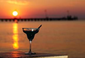 tropischer Cocktail mit Blick auf einen Sonnenuntergang Ozean