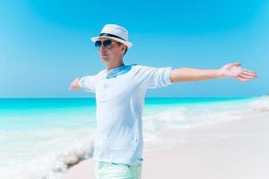 junger Mann am weißen tropischen Strand foto