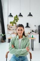 Frau sitzt auf einem Stuhl in einer modernen Küche foto