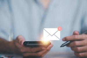 Mann liest E-Mail vom Smartphone, E-Mail-Marketing und Newsletter-Konzept, digitale Kommunikation mit E-Mail-Nachrichten, Senden und Empfangen von Nachrichten online mit dem E-Mail-Symbol foto