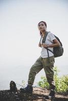 weibliche Reisende mit Rucksack auf schöner Sommerlandschaft foto
