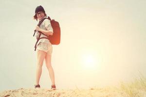 glückliche junge Hipsterfrau, die Rucksack bereit für die Reise trägt foto