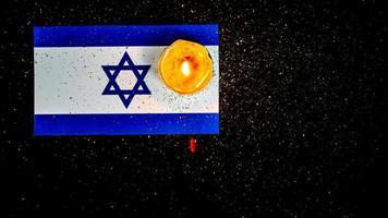 israelische flagge und kerzen, die darüber brennen, holocaust-gedächtnistag foto