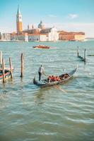 Venedig, Italien - 15.08.2019 traditionelle Gondeln im venezianischen Wasserkanal in Venedig. schöner touristischer Ort. reisen. gondoliere befördert touristen auf gondel grand canal von venedig, italien. foto