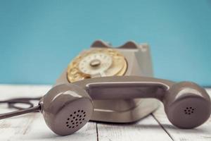 Braunes buntes Vintage-Telefon über einem weißen Holztisch foto