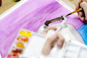 nahaufnahmehände, die pinsel und farbige palette mit aquarellfarben durch künstlermalerei halten foto