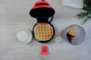 Waffeleisen mit Mini-Waffeln mit Ständer und Mini-Studio-Requisiten. foto