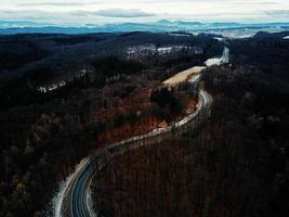 Landschaft mit kurvenreicher Straße durch Wald, Luftbild foto