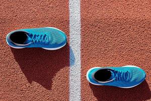 blaue Laufschuhe auf der Stadionstrecke foto