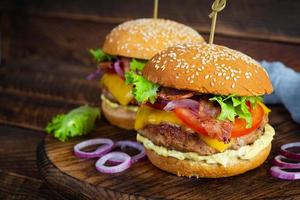 leckerer rindfleischhamburger mit speckscheibe, käse, salat und tomate. leckerer Fastfood-Burger foto