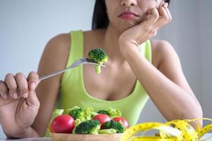 Schlanke Frauen sind gelangweilt davon, jeden Tag Salat zu essen foto