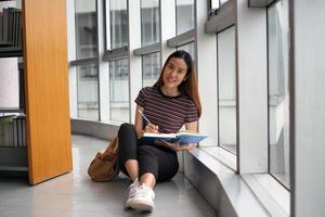 asiatische Studentinnen schreiben Bücher in der Bibliothek. foto