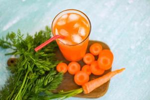 Karottensaft auf dem Hintergrund, frische und süße Karottenscheiben zum Kochen von Obst und Gemüse für das Gesundheitskonzept, frischer Karottensaft auf Glas mit Eis im Sommer foto