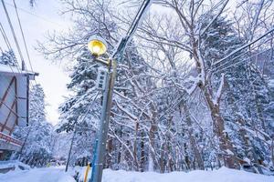 nikko, japan - 26. januar 2023. wolframlampe und ein japanisches dorfschild, stark verschneite straße im dorf heike no sato in der präfektur tochigi, stadt nikko, foto