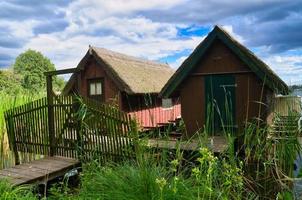 Fischerhütte am See in der Nähe von Krakau am See. Binnenfischerei. Weindach auf dem Haus foto