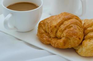 Buttercroissant und eine Tasse Kaffee zum Frühstück foto