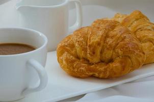 Buttercroissant und eine Tasse Kaffee zum Frühstück foto