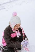 entzückendes kleines Mädchen, das sich am Wintertag amüsiert foto