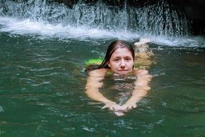 schönes Mädchen, das im Fluss schwimmt foto