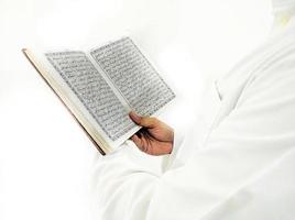 mann, der koran hält und liest. islamischer Hintergrund foto