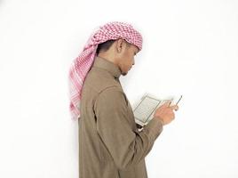 mann, der koran hält und liest. islamischer Hintergrund foto