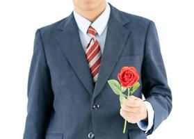 Geschäftsmann im Anzug mit roter Rose auf weiß foto