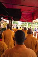 bandung, indonesien, 2020 - die mönche in orange rob stehen in ordnung, während sie zum gott am altar im buddha-tempel beten foto