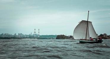 Segelboot und Landschaftsfoto der Industriestadt am Wasser foto