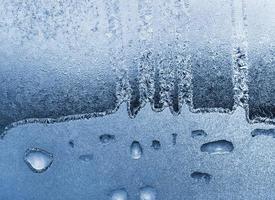 blaues Eismuster auf Glas, natürliche Winterstruktur foto