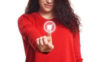 Mädchen, das virtuellen Knopf mit Warenkorb-Symbol drückt foto