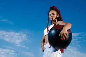 Hintergrund Himmel. sportliche Frau mit Medizinball. Kraft und Motivation. Foto einer sportlichen Frau in modischer Sportbekleidung