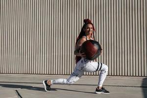 athletische Frau, die Longe-Übungen mit Medizinball macht. Kraft und Motivation. Foto einer sportlichen Frau in modischer Sportbekleidung