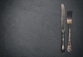 Vintage Eisengabel und Messer auf schwarzem Hintergrund foto