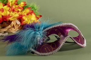 Venezianische Karnevalsmaske mit Federn und typischen Elementen im Hintergrund foto