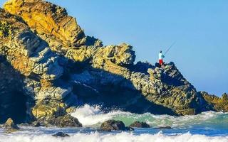 schöne felsen klippen surfer wellen am strand puerto escondido mexiko. foto