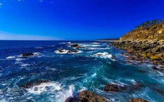 schöne felsen klippen anzeigen wellen am strand puerto escondido mexiko. foto