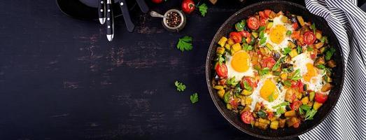 spätes Frühstück - Spiegeleier mit Gemüse. Shakshuka. Arabische Küche. koscheres Essen. Banner. Ansicht von oben foto