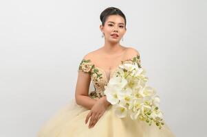 junge asiatische schöne Braut mit Orchideenblumenstrauß auf weißem Hintergrund foto