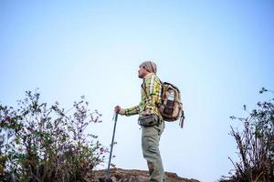 Porträt eines Mannes, der Berge mit Rucksack wandert foto