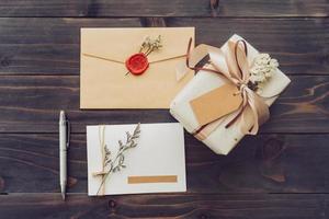 oben von Handwerk Geschenkbox und Grußkarte mit Stift auf Holztisch Hintergrund foto