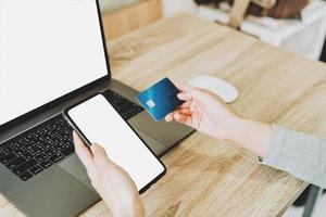 Frau mit Smartphone und Kreditkarte zum Online-Shopping im Café foto