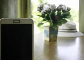 Smartphone in der Nähe von Tisch foto